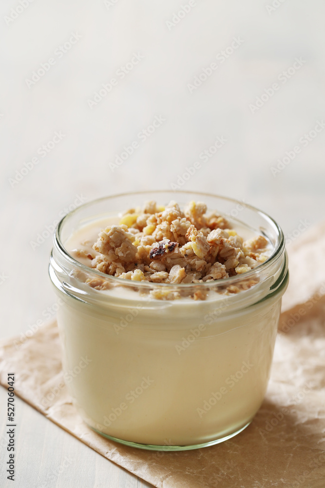 Homemade cooked healthy granola for breakfast in a wooden bowl on the table and near a bottle of milk. Place for text. Fitness food, snack Homemade cooked healthy granola for breakfast in a wooden bowl on the table and near a bottle of milk. Place for text. Fitness food, snack