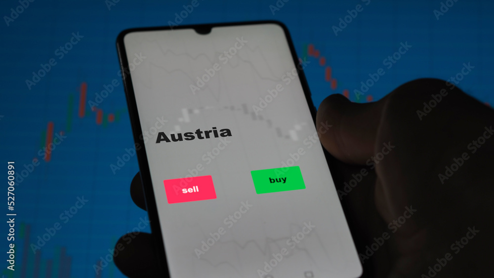 An investor's analyzing the Austria etf fund on screen. A phone shows