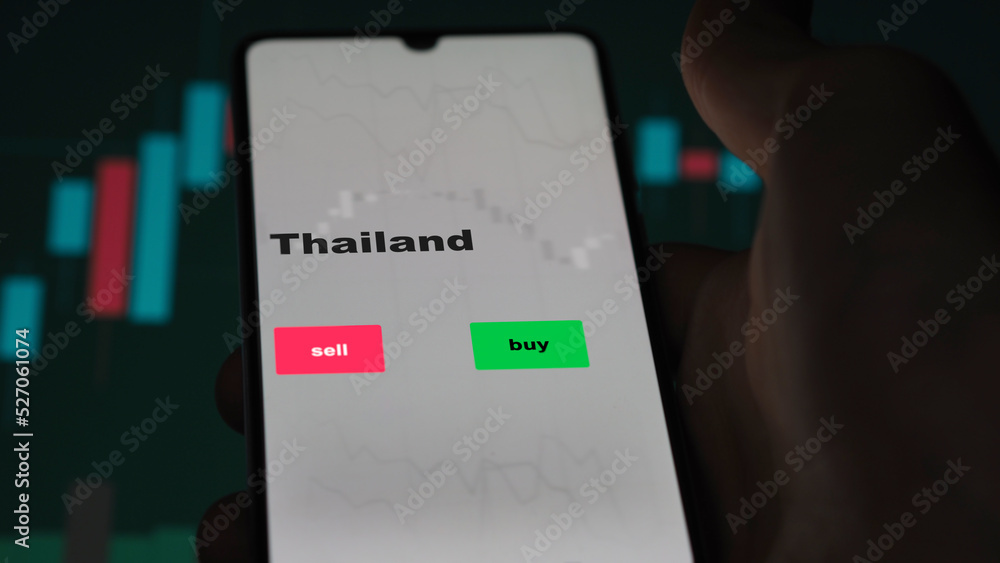 Un investisseur analyse le fonds ETF Thaïlande à l'écran. Un téléphone montre les prix des ETF thaïlandais à investir, texte en anglais. Un investisseur analyse le fonds ETF Thaïlande à l'écran. Un téléphone montre les prix des ETF thaïlandais à investir, texte en anglais.