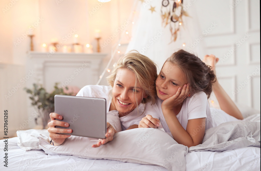 a woman and a little girl laying on a bed, having fun, film, elegant shot, photo of a beautiful, unique design, using a magical tablet a woman and a little girl laying on a bed, having fun, film, elegant shot, photo of a beautiful, unique design, using a magical tablet