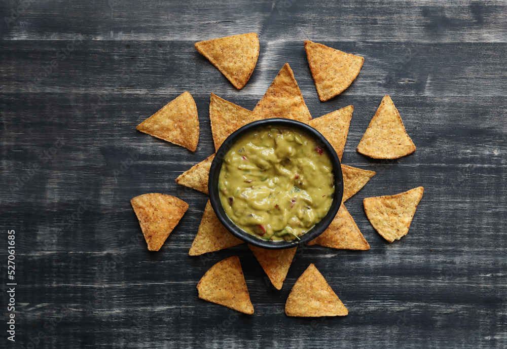 A Bowl Filled With Guacamole and Tortilla Chips A Bowl Filled With Guacamole and Tortilla Chips