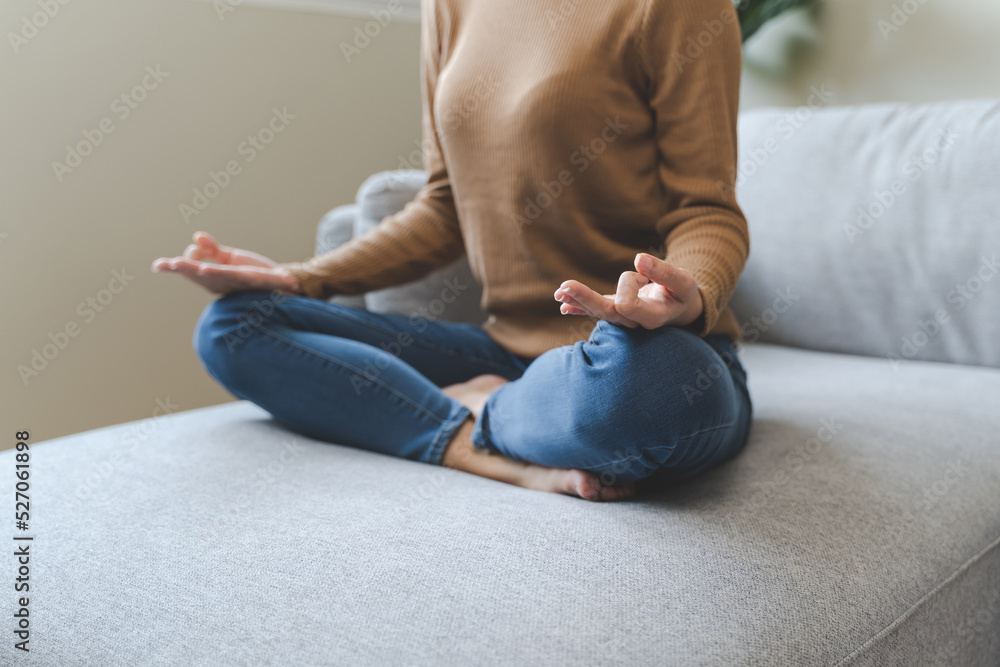 Wellbeing peaceful mind lifestyles,  Close up hand of young Asian women focus on breath harmony to refresh mindfulness on sofa in the living room at home.