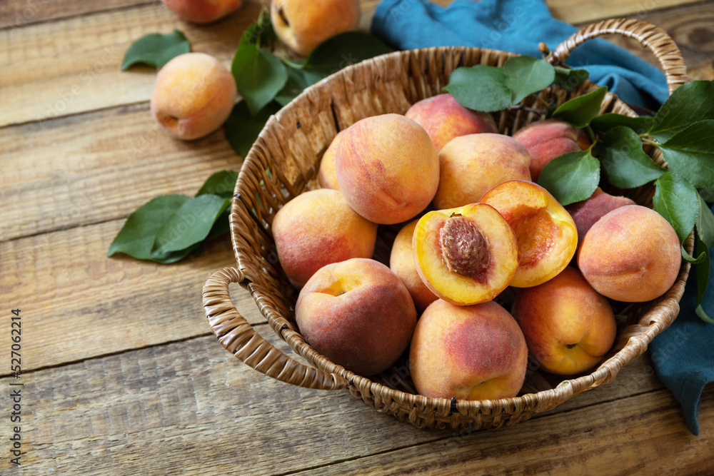 Fall harvest background. Organic fruits. Farmer's market. Basket of ripe peaches on a rustic wooden table. Copy space.