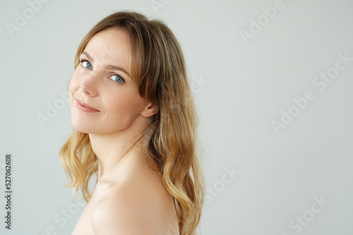 Picture of of young blond woman looks at camera and pose at home