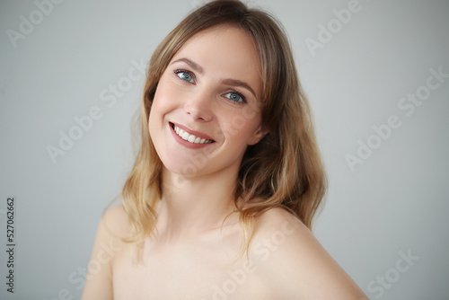 Close view of young blond woman looks at camera and pose at home