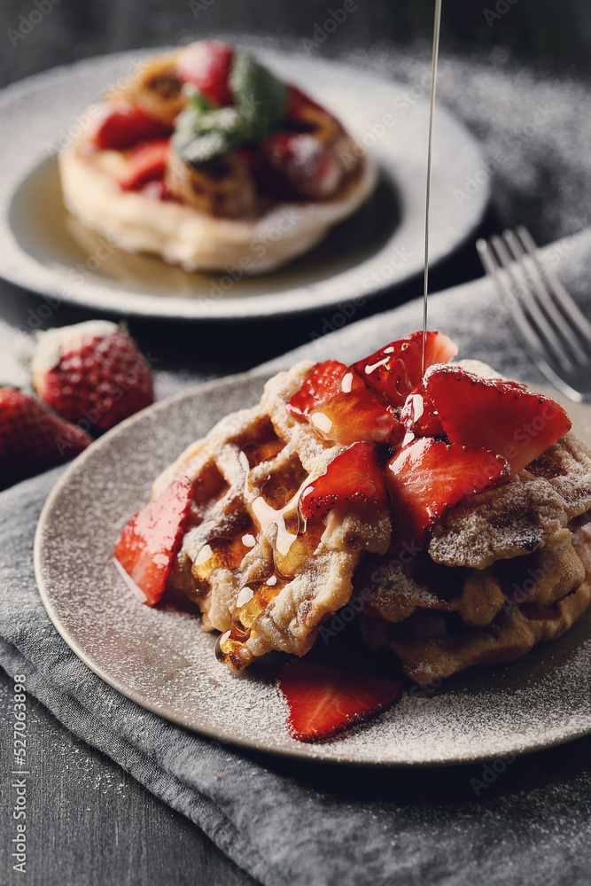 Beautifully decorated delicious sweet Belgian waffles with strawberries on the plate Beautifully decorated delicious sweet Belgian waffles with strawberries on the plate