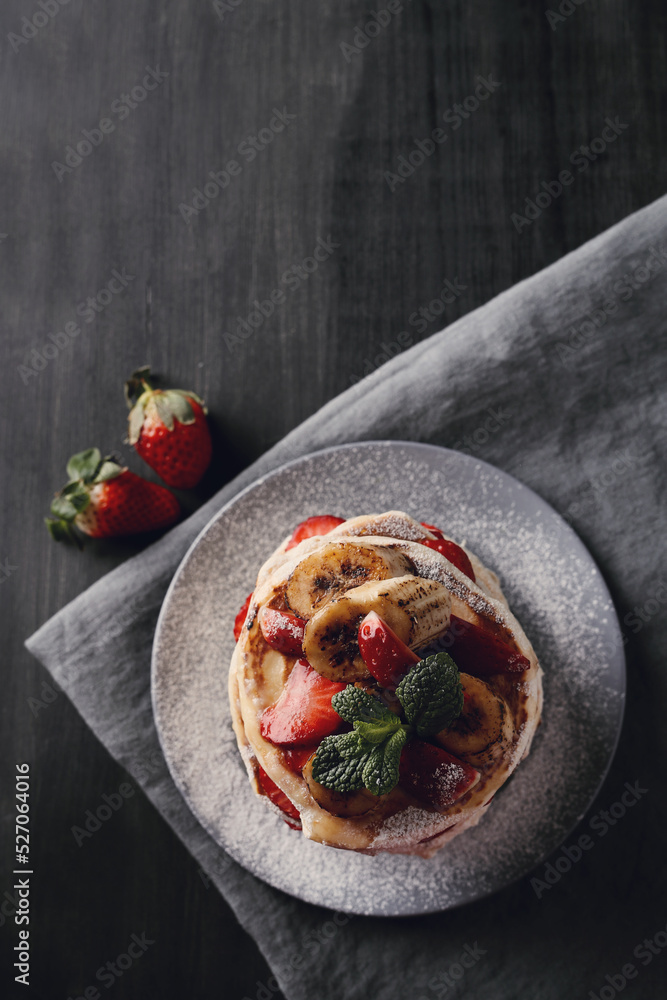 Beautifully decorated delicious sweet pancakes with fruits and honey on the plate Beautifully decorated delicious sweet pancakes with fruits and honey on the plate