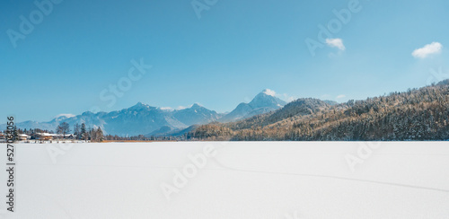 winter landscape with snow covered mountains an trees from frozen lake Weißensee in bavaria photo