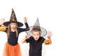 Kids on Halloween. A little girl and a boy in witch and sorcerer costumes in hats holding baskets in the shape of pumpkins making frightening gestures with their hands, saying Boo