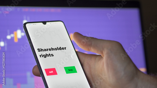 An investor's analyzing the shareholder rights etf fund on screen. A phone shows the ETF's prices stocks to invest