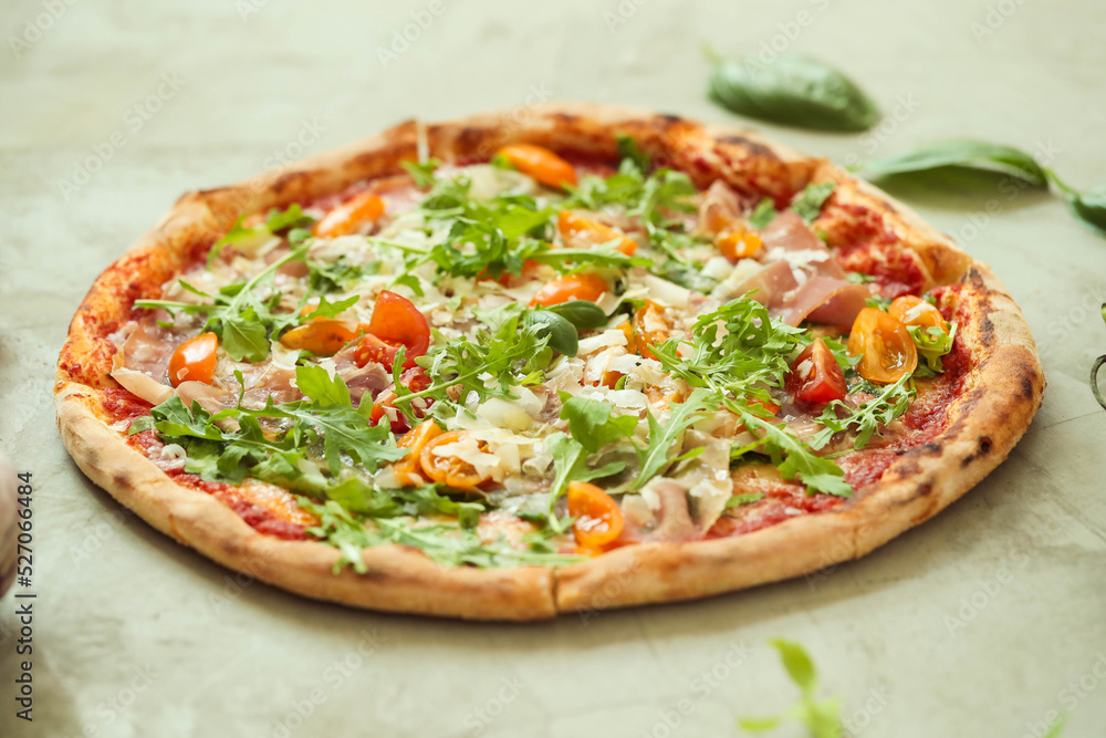 Picture of delicious hot whole pizza with vegetables on a light background