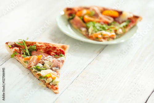Photo of delicious hot sliced pizza with vegetables on a wooden background