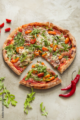 Photo of delicious hot sliced pizza with vegetables on a light background