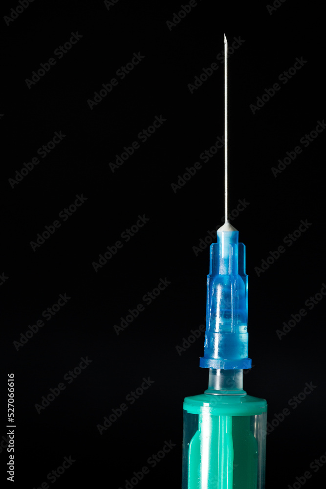 close up of needle with a syringe on a black background close up of needle with a syringe on a black background