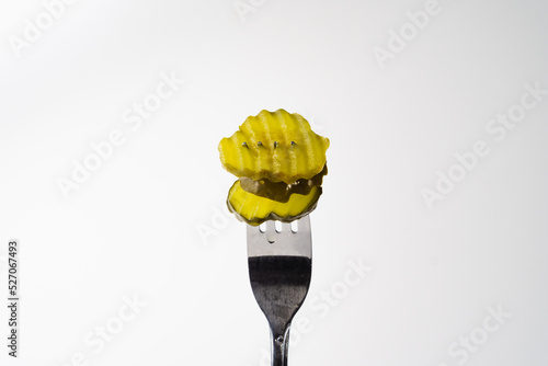Fotografie dill pickle chips in crinkle cut isolated on white background