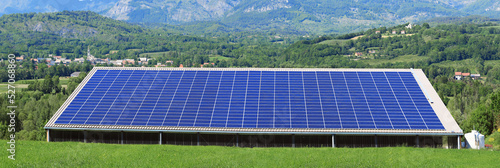 Grande surface de panneaux photovoltaïques sur une toiture de bâtiment.
