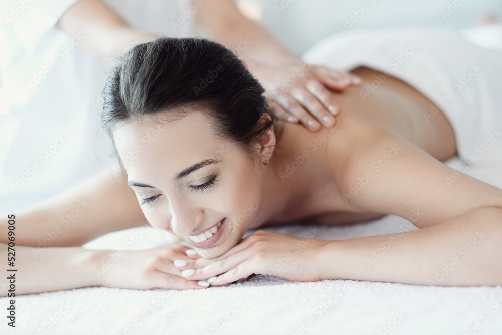 Women’s hands giving a relaxing massage to a beautiful young woman in the spa salon Women’s hands giving a relaxing massage to a beautiful young woman in the spa salon