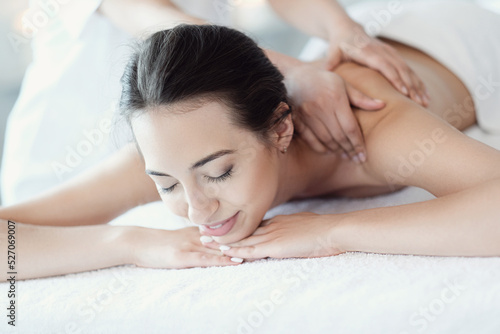 Women   s hands giving a relaxing massage to a beautiful young woman in the spa salon
