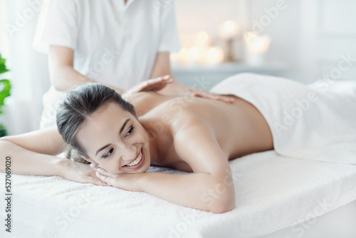 A beautiful young woman enjoying a back massage in the spa salon