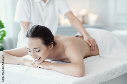 A beautiful young woman enjoying a back massage in the spa salon