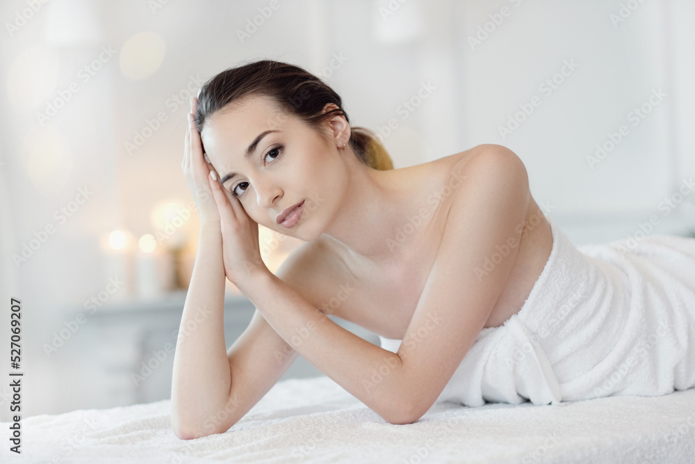 Relaxed beautiful young woman lying on the couch after massage in the spa Relaxed beautiful young woman lying on the couch after massage in the spa