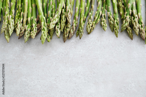 Overhead view of fresh green asparagus on light surface