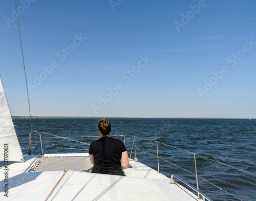 A girl in black clothes on a yacht is resting in the summer. Vacation travel. © Mi_Lara