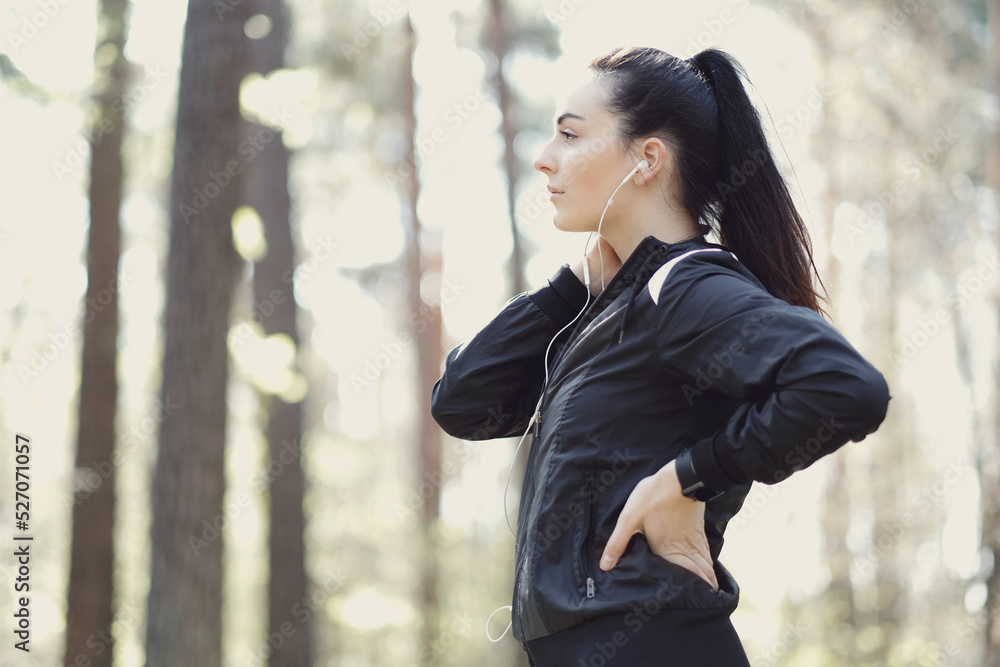 Young beautiful brunette woman posing in headphones in the woods early in the morning Young beautiful brunette woman posing in headphones in the woods early in the morning