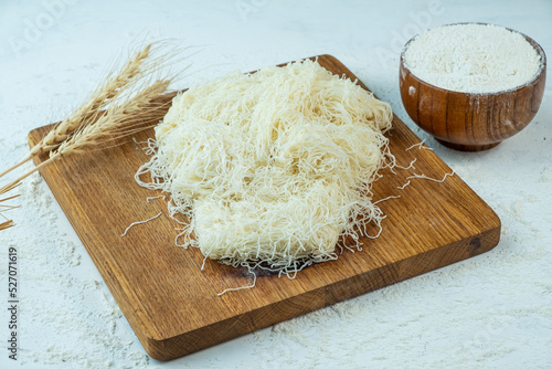 Kataifi dough on a wooden board, light table.