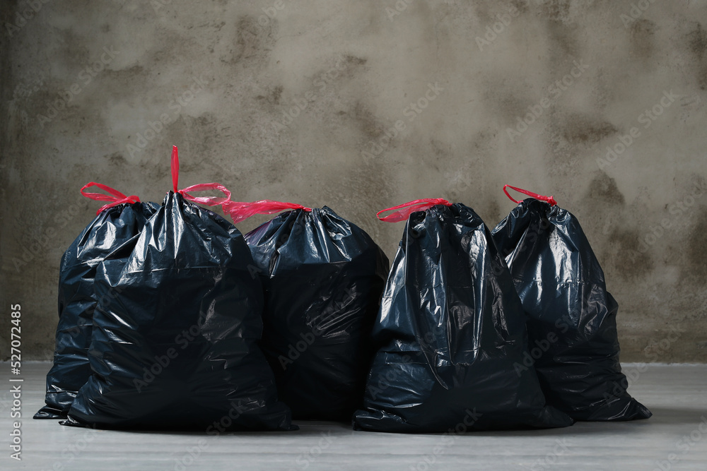 The big black garbage bags placed on the floor. The big black garbage bags placed on the floor.