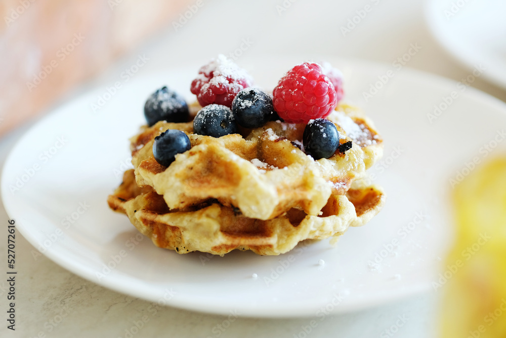 Breakfast of tasty mini Waffles with berries on a white plate Breakfast of tasty mini Waffles with berries on a white plate