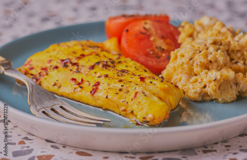 Φωτογραφία Smoked haddock fillet with scrambled egg and tomatoes.