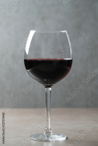 Image of one glass of red wine on a dark surface