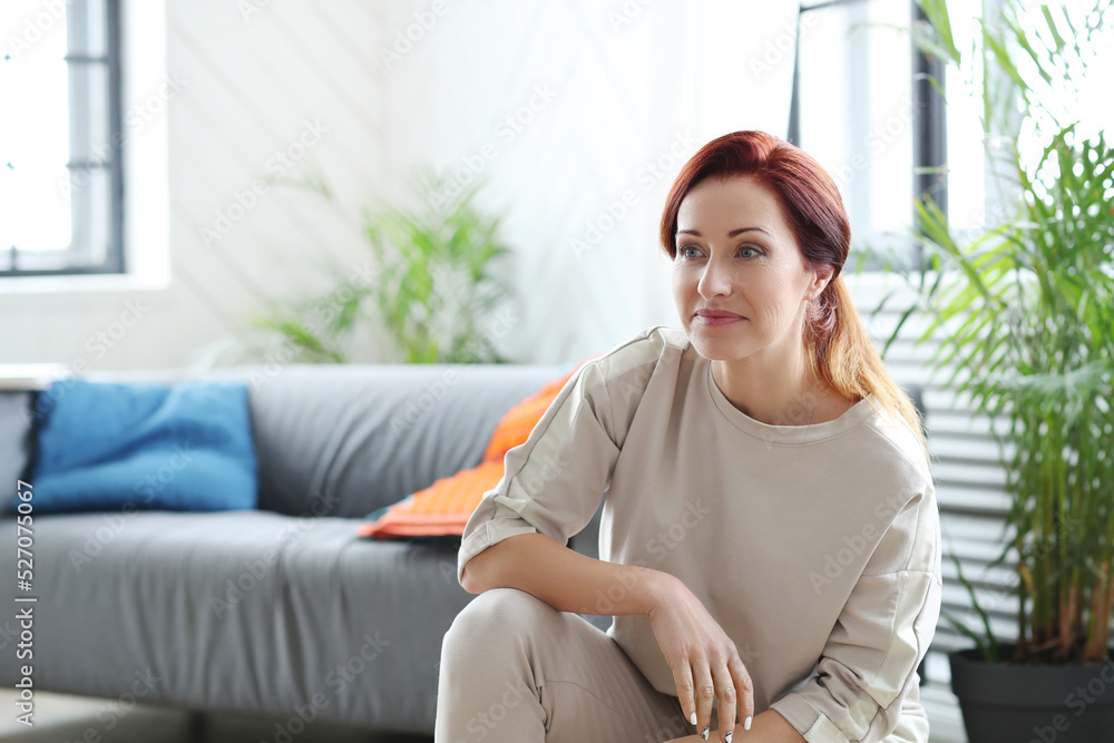 A beautiful red-haired woman crouching and looking away A beautiful red-haired woman crouching and looking away