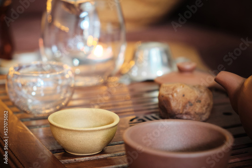 Glass teapot and tea cups made of yixing clay and glass stand on a bamboo tea tray. Chinese traditional gongfu cha teaware photo