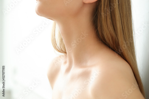 Сlose-up of a young blonde woman's neck on a white background