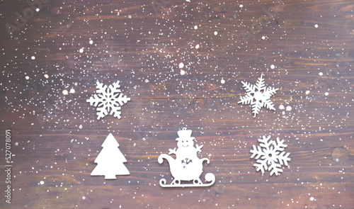 Christmas ornaments on wooden background with snowflakes. Concept for festive background or for design.