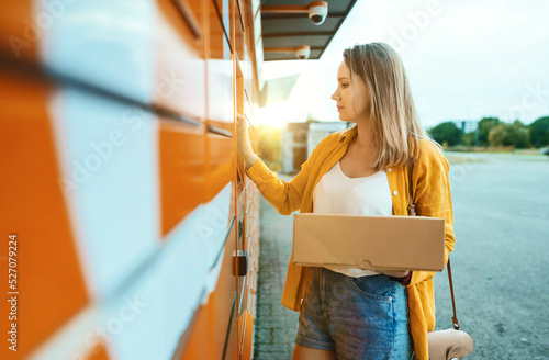 Woman sending mail via automated self-service post terminal machine.