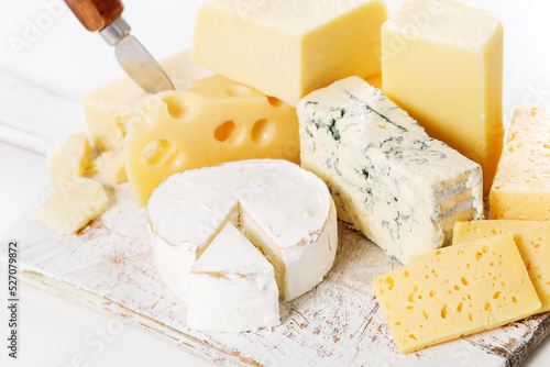 Different kinds of cheese isolated on a wooden cutting board.