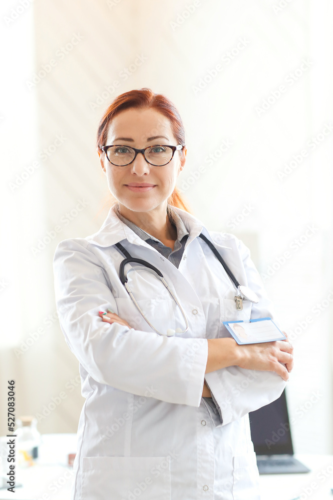 Confident female doctor with stethoscope standing with crossed arms on white background