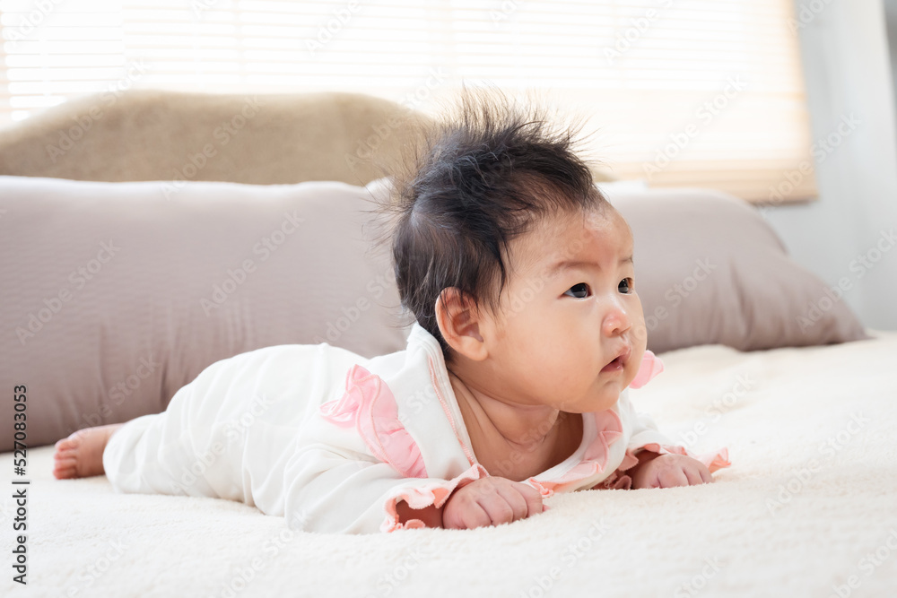 close-up of Newborn 3 month old Asian woman playing in bed in the bedroom of the house. After waking up, he looked for his mother in frustration, lowering his head and raising his head. close-up of Newborn 3 month old Asian woman playing in bed in the bedroom of the house. After waking up, he looked for his mother in frustration, lowering his head and raising his head.