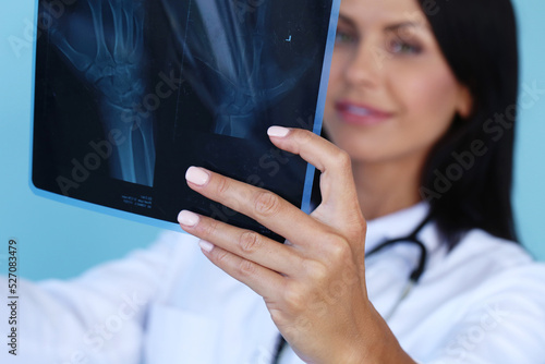 Female-doctor checking x-ray film in medical laboratory on a blue background.