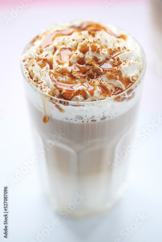 Close view of a tasty caramel milkshake in a glass on a white background.