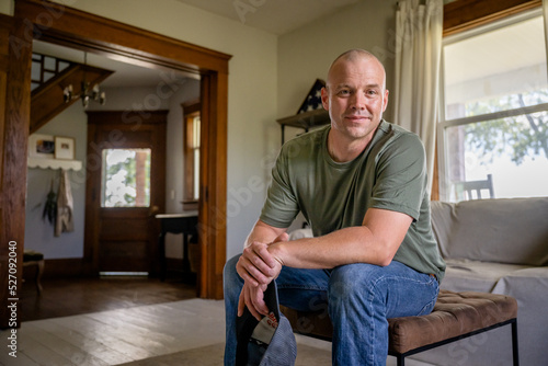 Marine veteran at home with family poses for portrait. photo