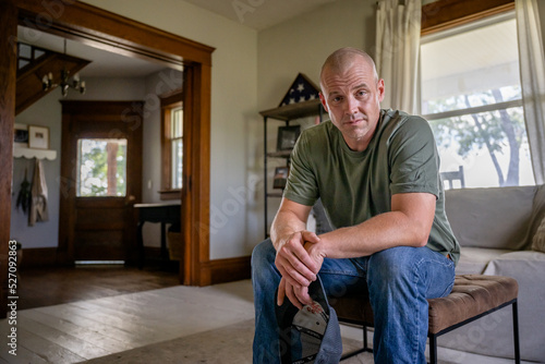 Marine veteran at home with family poses for portrait.