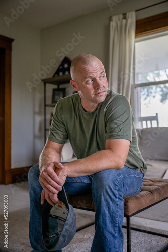 Marine veteran at home with family poses for portrait.