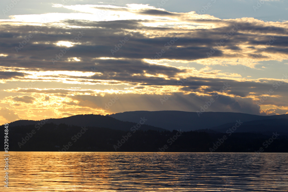 Sunset on lake with mountains and forests