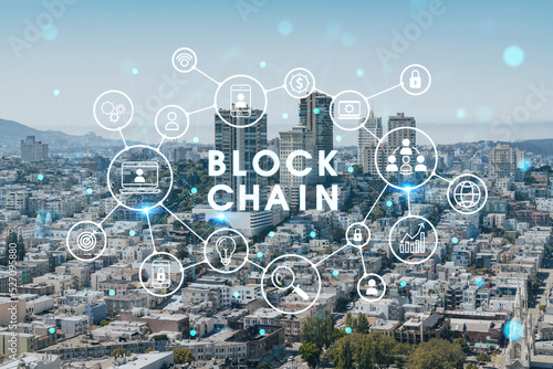 Panoramic cityscape view of San Francisco financial downtown at day time from rooftop, California, United States. Decentralized economy. Blockchain, cryptography and cryptocurrency concept, hologram