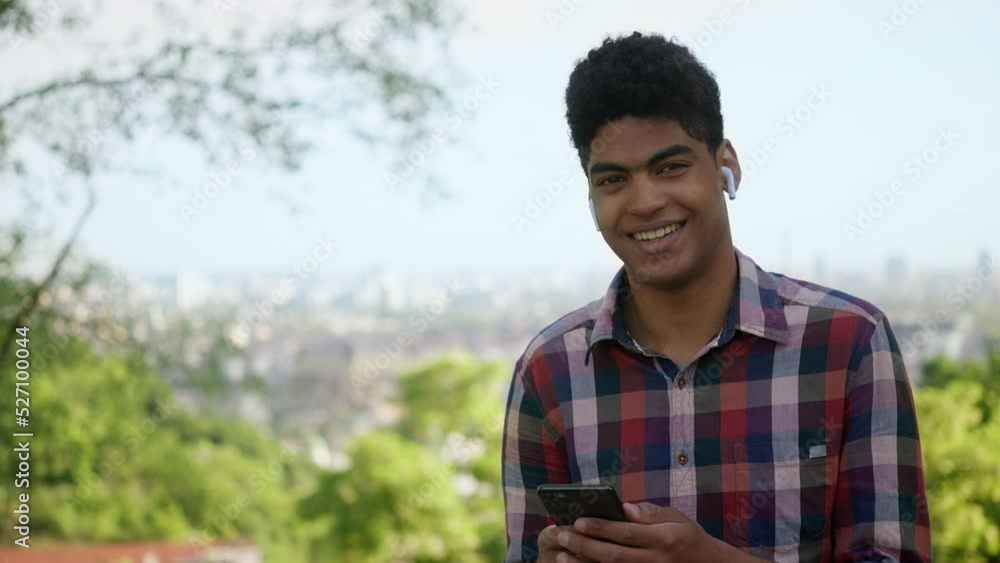 Portrait of African American teenager with smartphone and headphones, gadgets Portrait of African American teenager with smartphone and headphones, gadgets