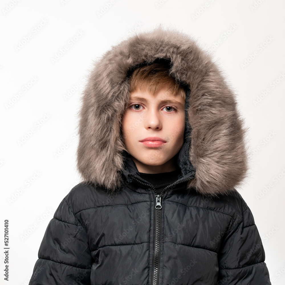Portrait of a child in a winter hat with earflaps and a knitted scarf on a white background. Portrait of a child in a winter hat with earflaps and a knitted scarf on a white background.